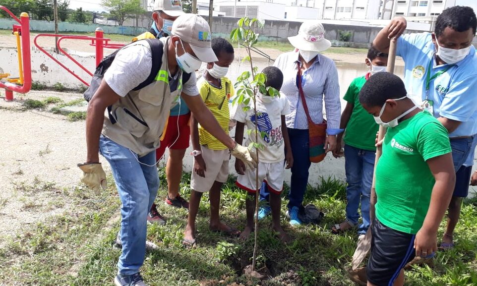 funcionarios y niños siembran árbol en recuperación de parque en el barrio pozón