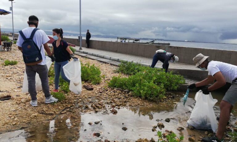 jovenes vigías y funcionarios en labores de recolección de basura en pro del cambio climático