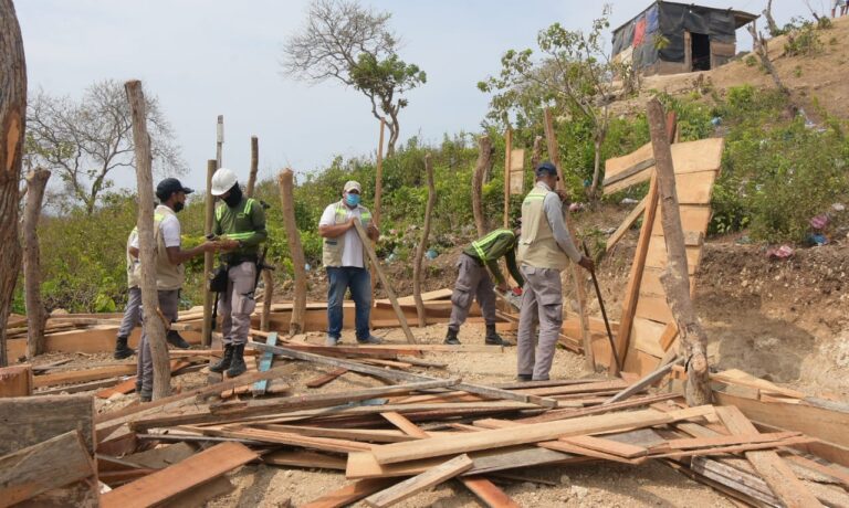 funcionarios desmontando vivienda de madera en el cerro de la popa
