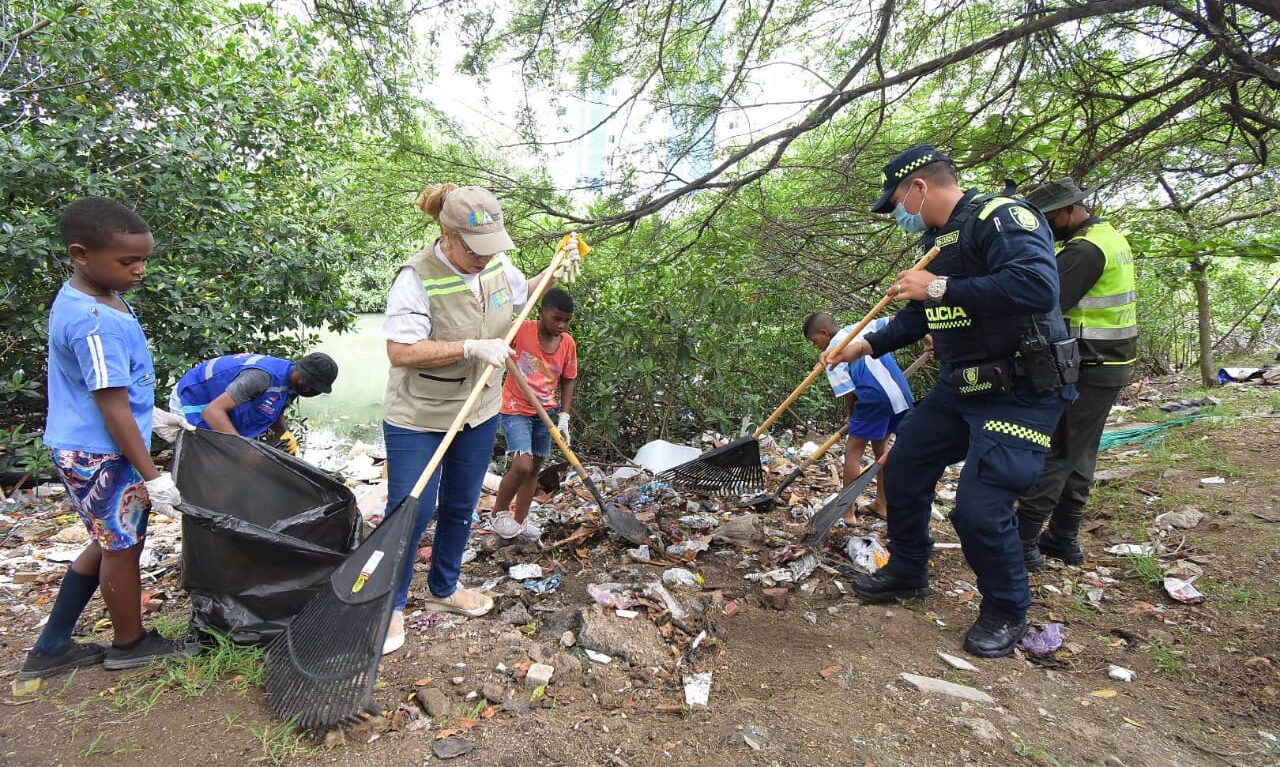 funcionarios y niños de la comunidad realizando limpieza para la recuperación del caño Juan Angola