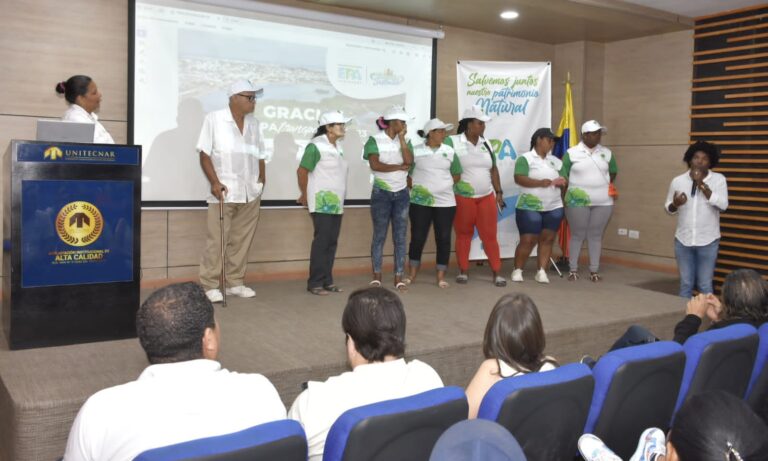 Funcionarios y asistentes en presentación de informe mi barrio sostenible.