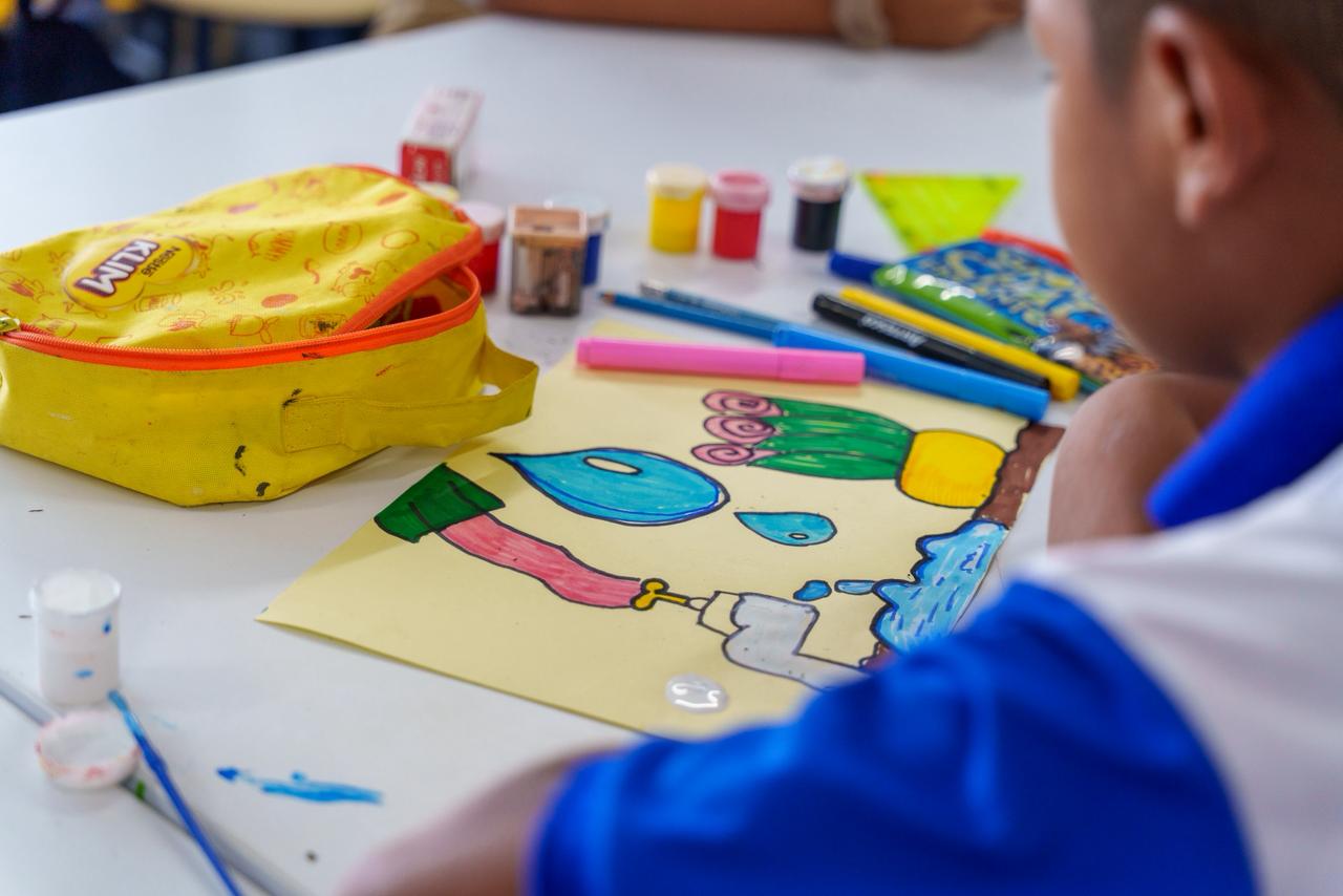 Fotografía de niño estudiante realizando dibujo sobre día mundial del agua